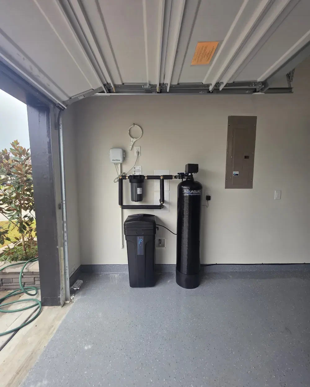 The finished install: softener, pre-filter and brine tank plumbed into the same wall loop.